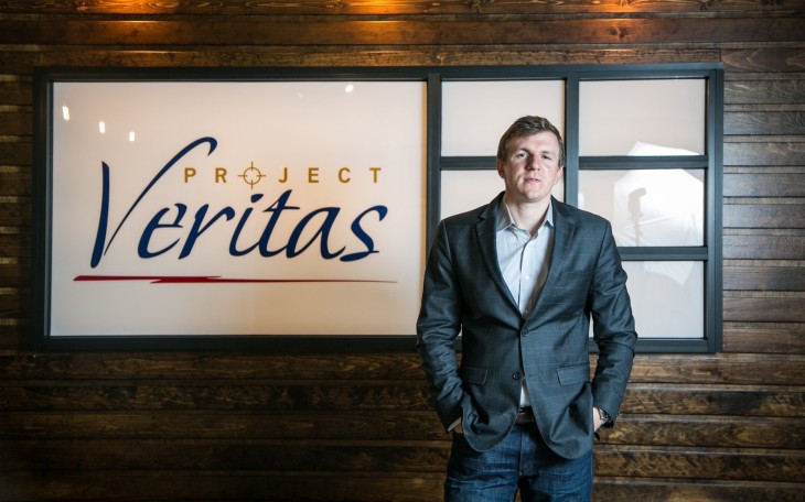 James O'Keefe, fundador do Project Veritas, em frente a logotipo do projeto